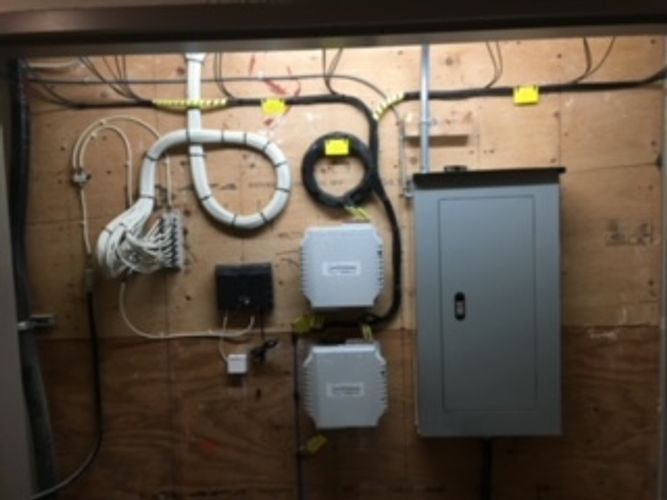 A bunch of wires are hanging on a wall.